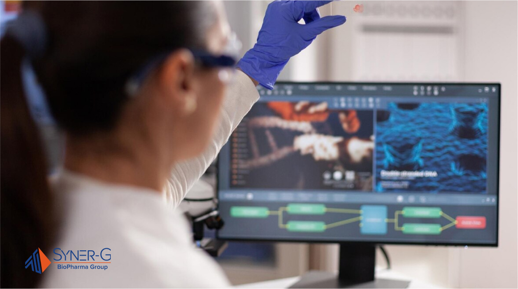 Female scientist analyzing a blood sample in front of a computer monitor, with lab equipment and digital data displayed on the screen.