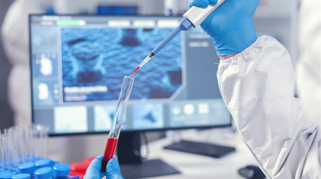 Medical researcher dripping blood into a test tube from a micropipette. Doctor working with various bacteria and tissue, pharmaceutical research for antibiotics against covid19.